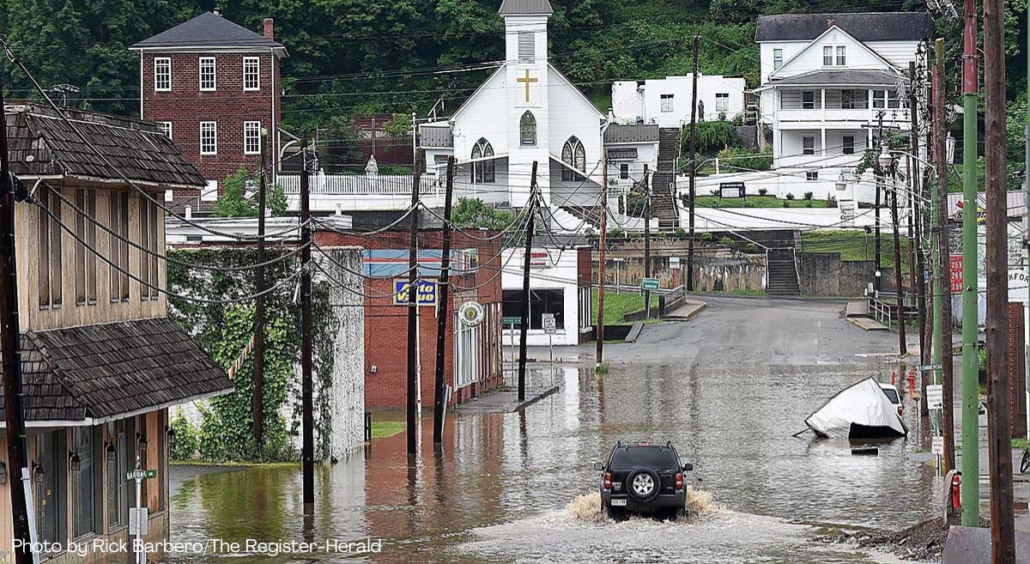 A vehicle makes a wake along the flooded Lower Oakford Ave. Friday, June 24, 2016, in Richwood, W.Va. (Rick Barbero_The Register-Herald)